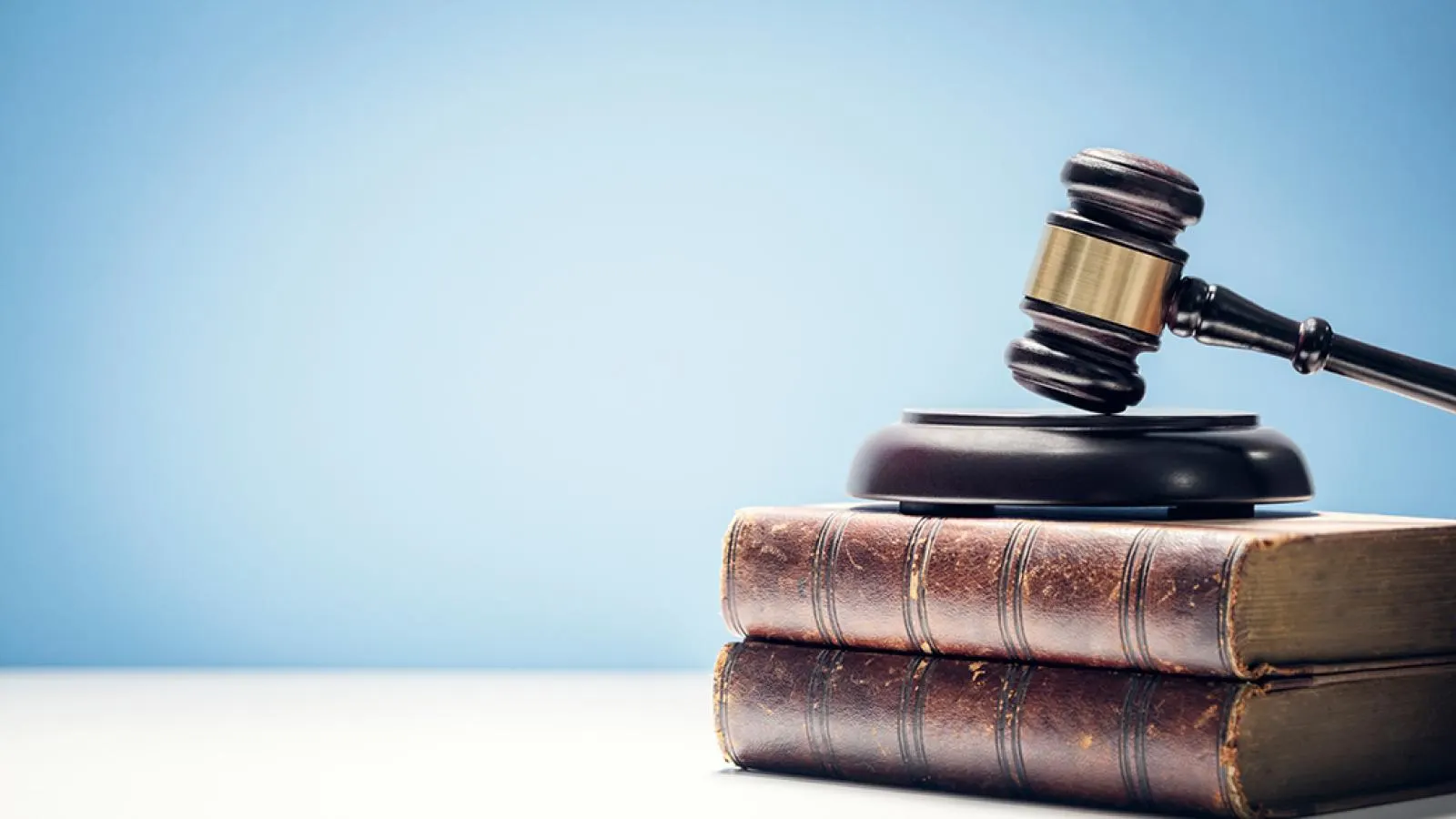 Judge gavel on law books with blue background